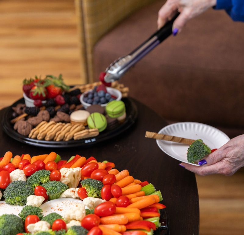 resident selecting food from an assortment