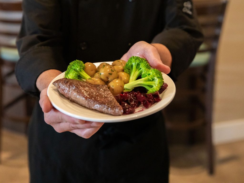 team member holding plate of food